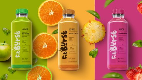 The vibrant packaging and branding we designed for juice company FitBurst, shown on three different flavor bottles with fresh fruit ingredients.